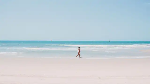 Caminhada relaxante na praia de Canoa Quebrada, evocando fragrâncias leves e refrescantes para o verão