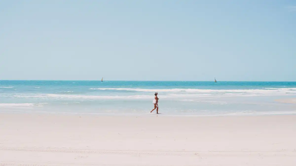 Caminhada relaxante na praia de Canoa Quebrada, evocando fragrâncias leves e refrescantes para o verão