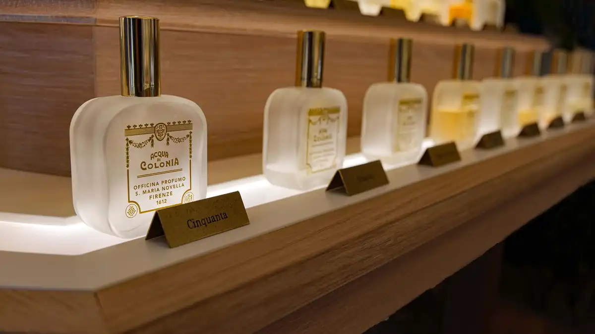 Frascos de perfume alinhados em prateleira organizada — ilustra armazenamento adequado longe de luz direta