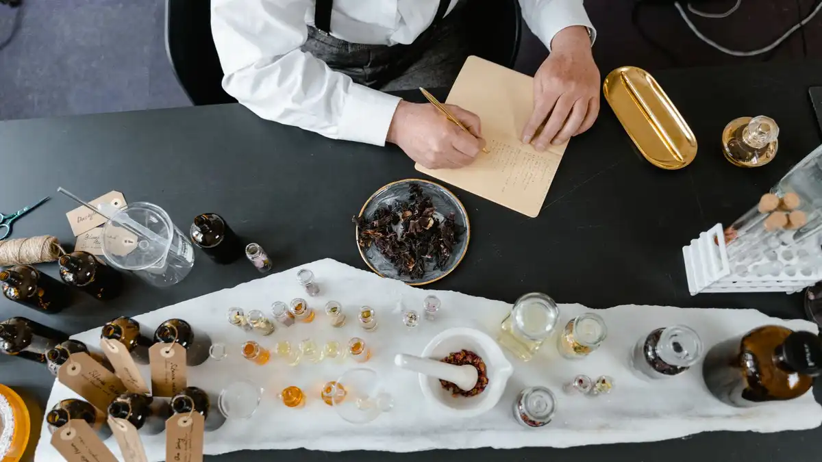 Almofariz e ingredientes aromáticos em bancada de trabalho, representando a classificação e composição dos perfumes