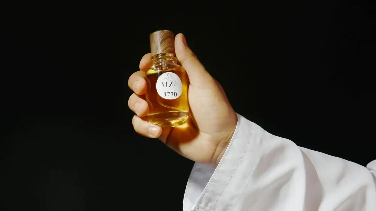Frascos de perfume dourados e âmbar alinhados, evocando fragrâncias orientais
