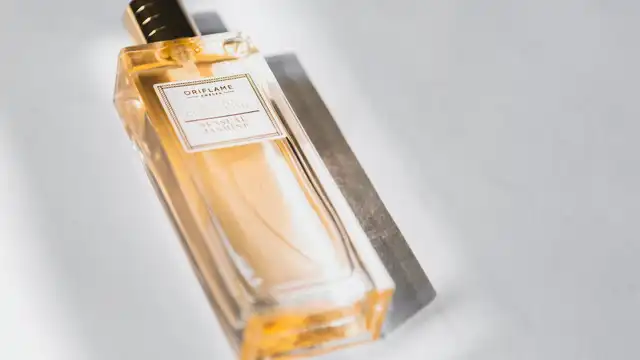 Frasco de perfume feminino elegante sobre superfície clara