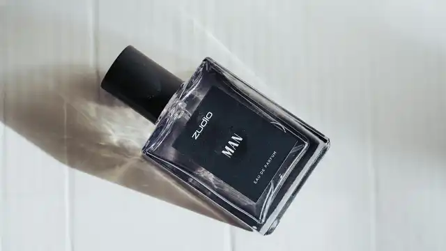 Frasco de perfume masculino preto com sombra dramática sobre fundo branco — estética esportiva e sofisticada da linha Ferrari