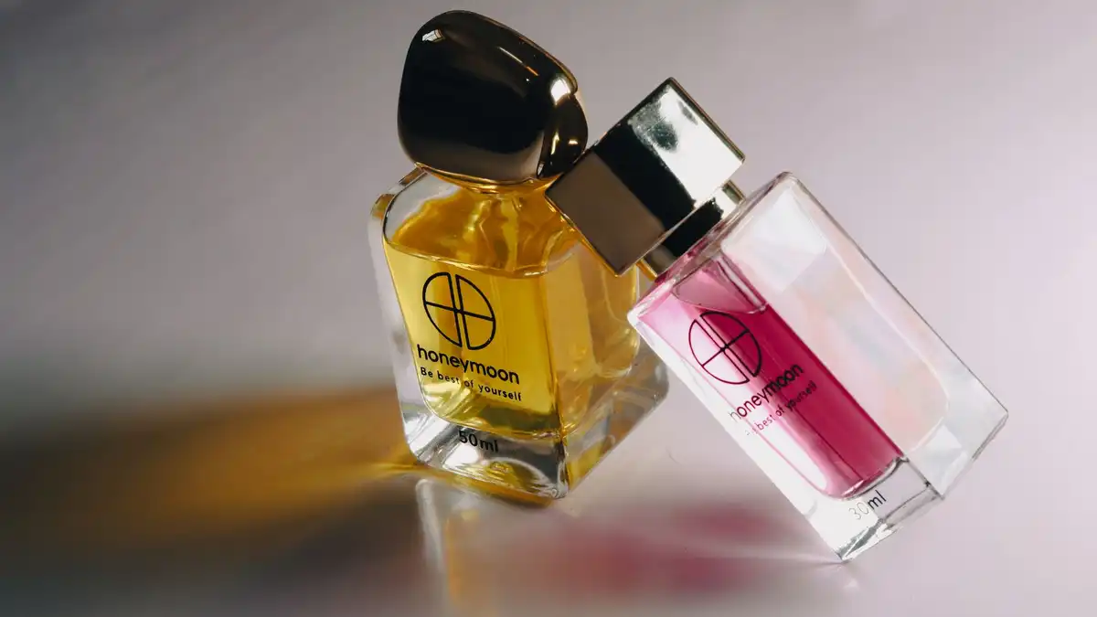 Frasco de perfume feminino em tom âmbar sobre fundo claro, representando fragrâncias importadas de luxo