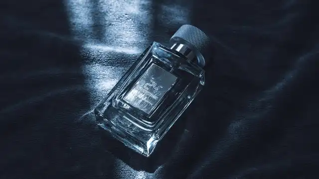 Frasco de perfume masculino de luxo em vidro sobre tecido escuro texturizado