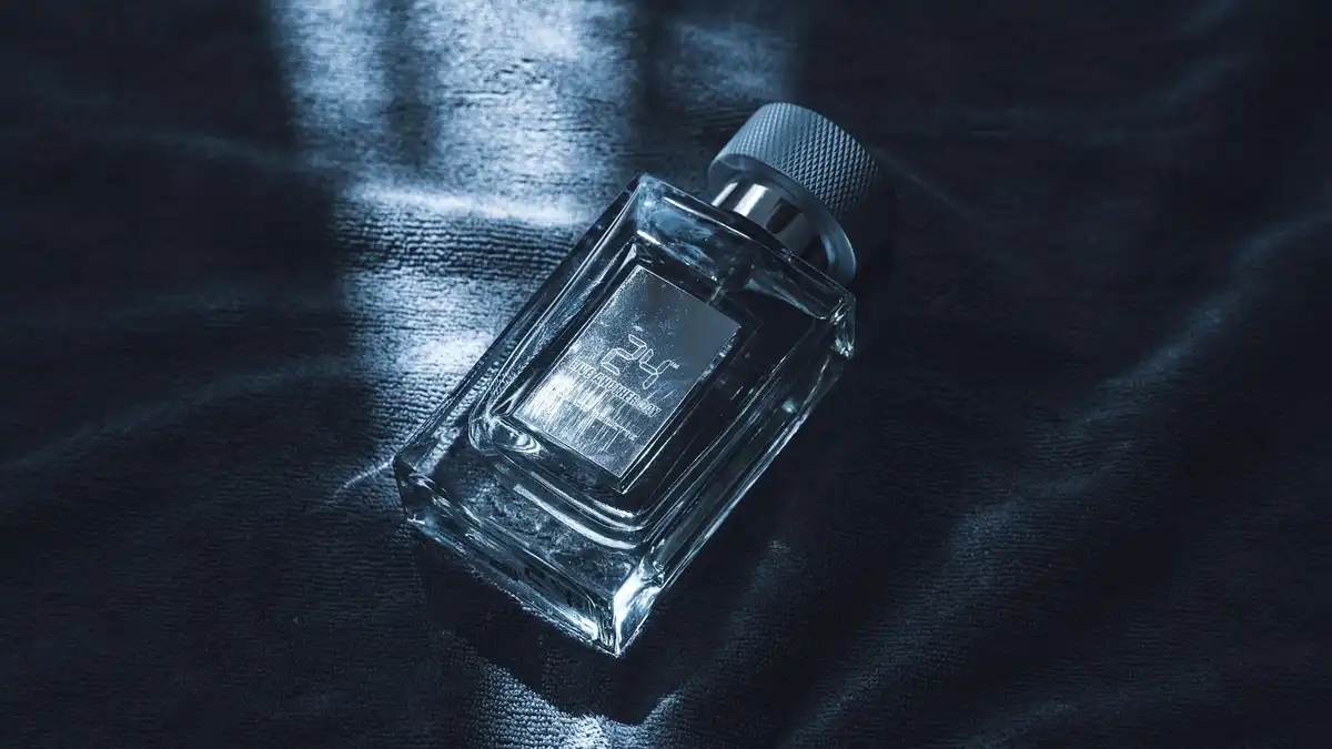 Frasco de perfume masculino de luxo em vidro sobre tecido escuro texturizado