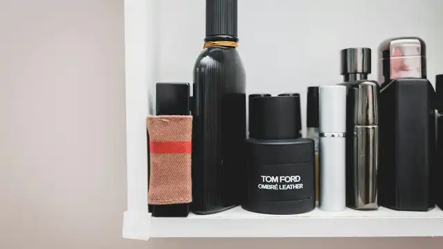 Prateleira com diversos frascos de perfumes e colônias masculinas alinhados