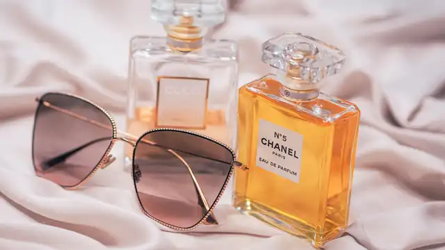 Frascos de perfume Chanel sobre tecido claro em composição suave e onírica