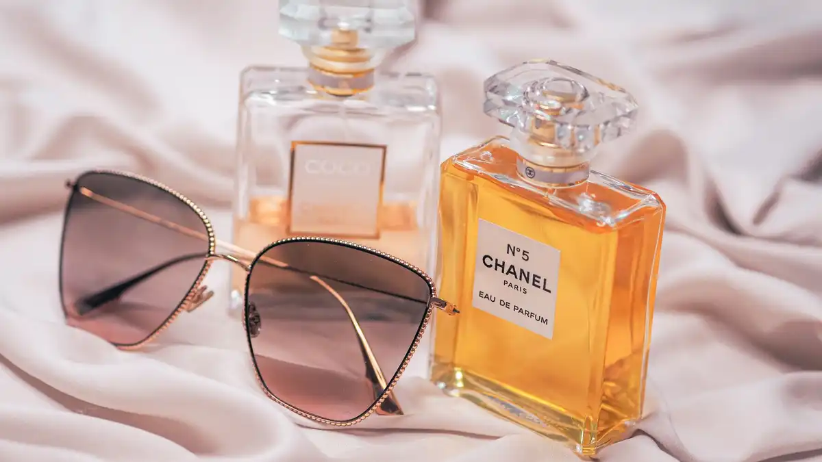 Frascos de perfume Chanel sobre tecido claro em composição suave e onírica