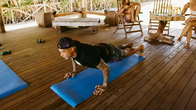Homem fazendo flexão em academia ao ar livre, representando treino e cuidado pessoal